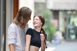 uma casal é desfrutando uma verão período de férias dentro a comunidade ruas, alegremente mostrando seus amor para cada outro. foto