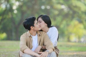 lgbt casal é desfrutando uma verão período de férias dentro a parque, alegremente mostrando seus amor para cada outro. foto