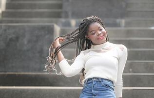 uma jovem mulher com dele Penteado e a atmosfera do vivo dentro a comunidade. foto