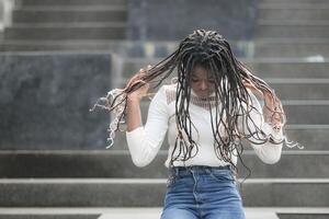 uma jovem mulher com dele Penteado e a atmosfera do vivo dentro a comunidade. foto