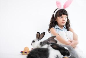 sorridente pequeno menina e com seus Amado fofo coelho, exibindo a beleza do amizade entre humanos e animais foto