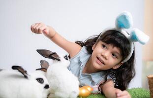 sorridente pequeno menina e com seus Amado fofo coelho, exibindo a beleza do amizade entre humanos e animais foto