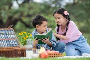 feliz família desfrutando uma piquenique dentro a parque, crianças sentado e lendo livros. foto