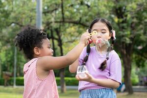 meninas dentro a parque com sopro ar bolha, cercado de vegetação e natureza foto