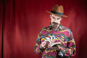 vintage hipster homem com copos, chapéu e bigode assistindo uma livro foto