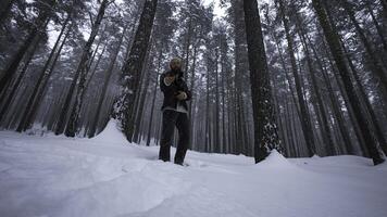 homem raps dentro inverno floresta. meios de comunicação. à moda homem movimentos dentro quadril pulo estilo dentro inverno floresta. homem lê quadril pulo dentro inverno floresta foto