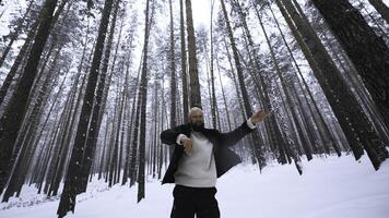 homem dançando dentro inverno floresta. meios de comunicação. à moda homem filmando vídeo grampo dentro inverno floresta. tiroteio à moda homem dentro inverno floresta foto