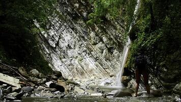 mulher cruzando montanha frio água corrente com pedras. criativo. caminhante dentro pitoresco lugar. foto