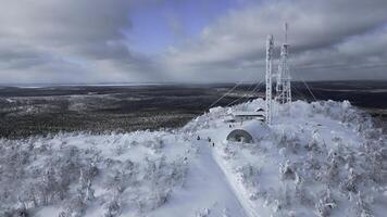 uma voar sobre a denso inverno siberian floresta dentro a tarde. grampo. branco montanha e uma congeladas clima torre em Está topo. foto