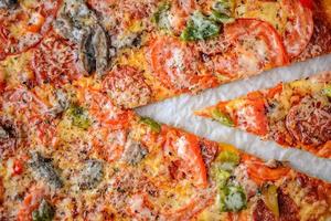 pizza com salame, tomate, pimenta e cogumelos é a vista de cima. foto