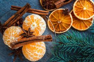 tangerinas, laranjas secas, anis e paus de canela em uma mesa de madeira foto