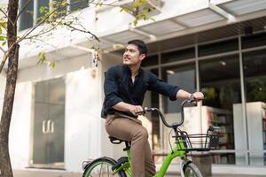 eco amigável, feliz estilo de vida ásia jovem homem de negocios passeio bicicleta ir para escritório trabalhos às cidade rua com bicicleta dentro manhã foto