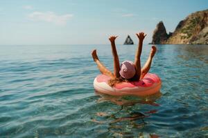 verão período de férias mulher dentro chapéu flutua em a inflável rosquinha colchão. feliz mulher relaxante e desfrutando família verão viagem feriados viagem em a mar. foto