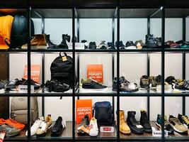 budva, Montenegro - 25 dezembro 2022. Esportes homens sapatos e acessórios estão em a prateleiras dentro uma desconto loja foto