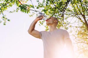 jovem atleta é refrescante ele mesmo com água, esporte e saudável estilo de vida foto