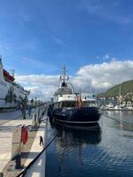 herceg-novi, Montenegro - 17 agosto 2023. motor iate ancorado em a cais contra a pano de fundo do montanhas foto