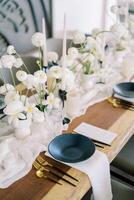 cardápios mentira perto Preto pratos em uma festivo mesa com branco flores em uma limitar toalha de mesa foto