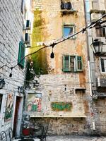 kotor, Montenegro - 25 dezembro 2022. vintage fachada do uma pedra arranha-céus construção com persianas, quadros e ar condicionadores foto