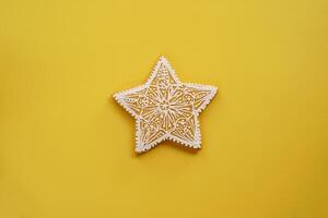 envidraçado openwork branco Pão de gengibre Estrela mentiras em uma amarelo fundo foto