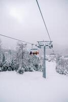 teleférico com esquiadores sobe uma Nevado declive dentro a kolasin 1600 recorrer. Montenegro foto