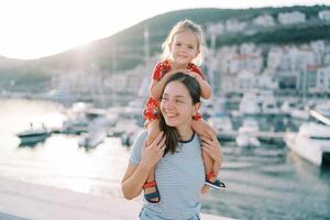 alegre mãe e filha desfrutando uma ensolarado dia às a marina foto