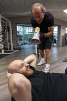 Senior treinador gritando com uma megafone às a jovem atleta foto