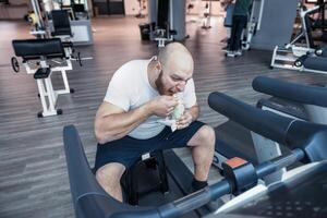 corredor atleta relaxante comendo a gelo creme em a dirigindo maquinaria foto