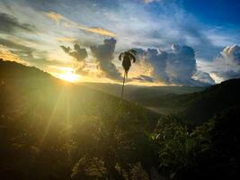 Maravilhoso brilhando pôr do sol Visão com montanha e Colina fundo. natureza beleza conceito foto