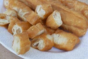 fechar acima Visão do cortar cakoi ou youtiao bolo em branco placa. ásia Comida conceito foto