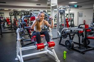 jovem esporte mulher vestindo esporte vestem fazendo exercício com ginástica equipamento às academia, ela exercício para Forte e Boa saudável. Alto qualidade foto