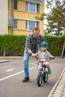 feliz família pai ensina criança filha para passeio público bicicleta em 1 do tráfego Parque infantil dentro Praga, tcheco república, Europa. Alto qualidade foto