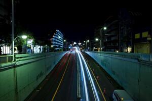uma noite tráfego geléia às a urbano rua dentro Tóquio Largo tiro foto