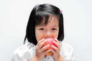 criança está com fome de comer maçãs. as crianças comem frutas para adicionar vitaminas ao corpo. foto