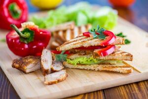 frito torrada com frango, salada, verduras em uma de madeira mesa foto