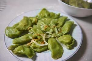 fechar-se do uma prato com recentemente cozinhou dumplings com amassado batatas, em uma mármore mesa. culinária. caseiro culinária. Comida blogging. ucraniano ou italiano tradicional refeição. Visão a partir de acima foto