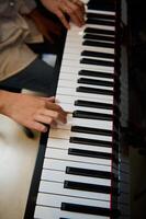 músico Garoto jogando grande piano durante música lição, realizando clássico melodia, criando e sentindo-me a ritmo do sons enquanto colocando dedos em branco e Preto piano chaves. fechar-se topo visualizar. foto