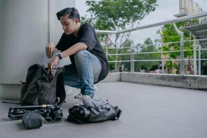 indonésio masculino fotógrafo é embalagem bagagem e obtendo pronto para viagem. feriado viagem conceito. foto