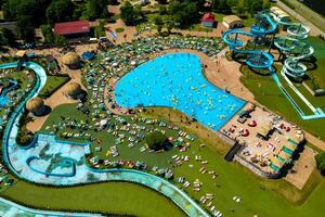 topo Visão do pessoas relaxante dentro a piscina em amarelo inflável círculos e Sol camas em a de praia foto