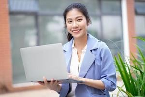 jovem mulher asiática trabalhando fora foto