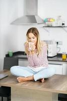 jovem segurando uma xícara de café em casa. foto