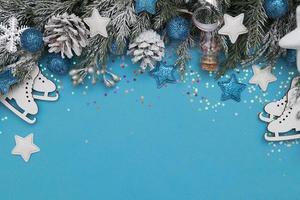 cartão de decoração de férias de inverno conceito festivo árvores de natal, estrelas, patins e bolas no fundo azul foto