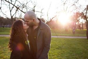 homem e mulher felizes se beijando em pé no jardim de outono foto