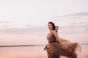 garota na margem de um lago salgado rosa foto