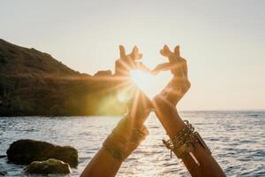 mulher mar ioga. feliz mulher dentro branco roupa de banho e boho estilo braquetes praticando ao ar livre em ioga esteira de mar em pôr do sol. mulheres ioga ginástica rotina. saudável estilo de vida, harmonia e meditação foto