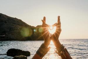 mulher mar ioga. feliz mulher dentro branco roupa de banho e boho estilo braquetes praticando ao ar livre em ioga esteira de mar em pôr do sol. mulheres ioga ginástica rotina. saudável estilo de vida, harmonia e meditação foto