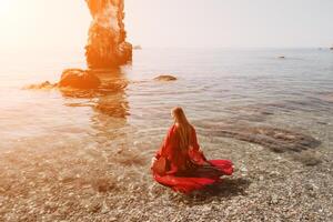 mulher viagem mar. feliz turista dentro vermelho vestir apreciar levando cenário ao ar livre para recordações. mulher viajante posando em a Rocha às mar baía cercado de vulcânico montanhas, partilha viagem aventura viagem foto