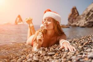 mulher viagem mar. feliz turista apreciar levando cenário em a de praia para recordações. mulher viajante dentro santa chapéu parece às Câmera em a mar baía, partilha viagem aventura viagem foto