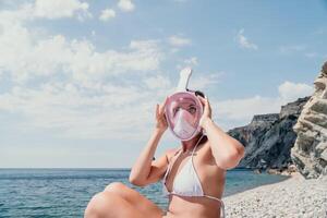 jovem feliz mulher dentro branco bikini e vestindo Rosa mascarar pega pronto para mar mergulho. positivo sorridente mulher relaxante e desfrutando água Atividades com família verão viagem feriados período de férias em mar. foto