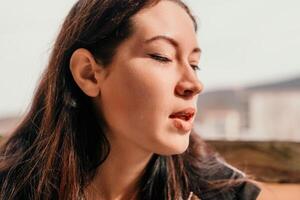 feliz jovem sorridente mulher com sardas ao ar livre retrato. suave ensolarado cores. ao ar livre fechar-se retrato do uma jovem morena mulher e olhando para a Câmera, posando contra outono natureza fundo foto