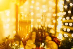 dois champanhe óculos preenchidas com champanhe estão colocada em uma mesa com uma fruta arranjo. a óculos estão cercado de luzes, criando uma festivo atmosfera. foto